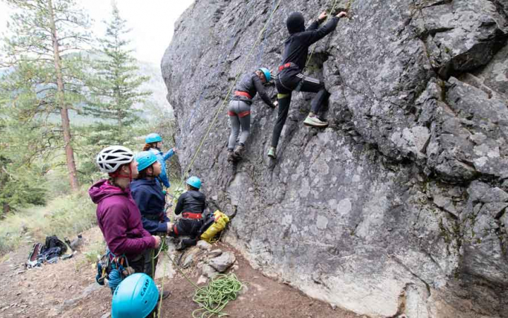 a group of girls rock climbing on outward bound expedition